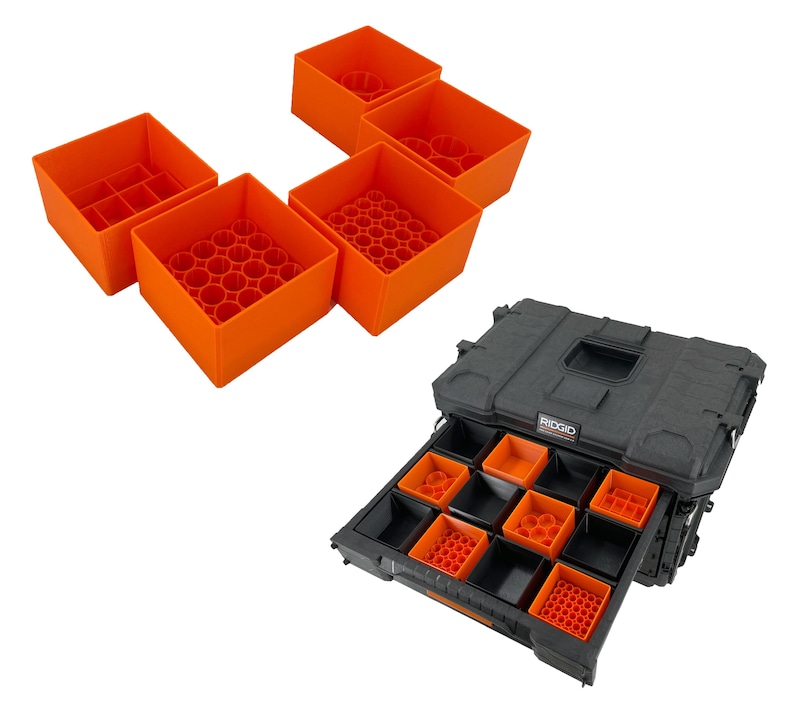 May include: A black toolbox with a drawer that is open. The drawer is filled with orange plastic organizers. The toolbox has the word "RIDGID" printed on the side.