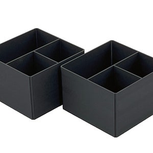May include: Two black plastic organizers with four compartments each. The organizers are empty and are sitting on a white background.