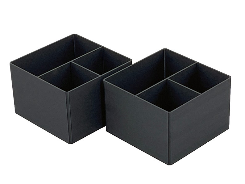 May include: Two black plastic organizers with four compartments each. The organizers are empty and are sitting on a white background.