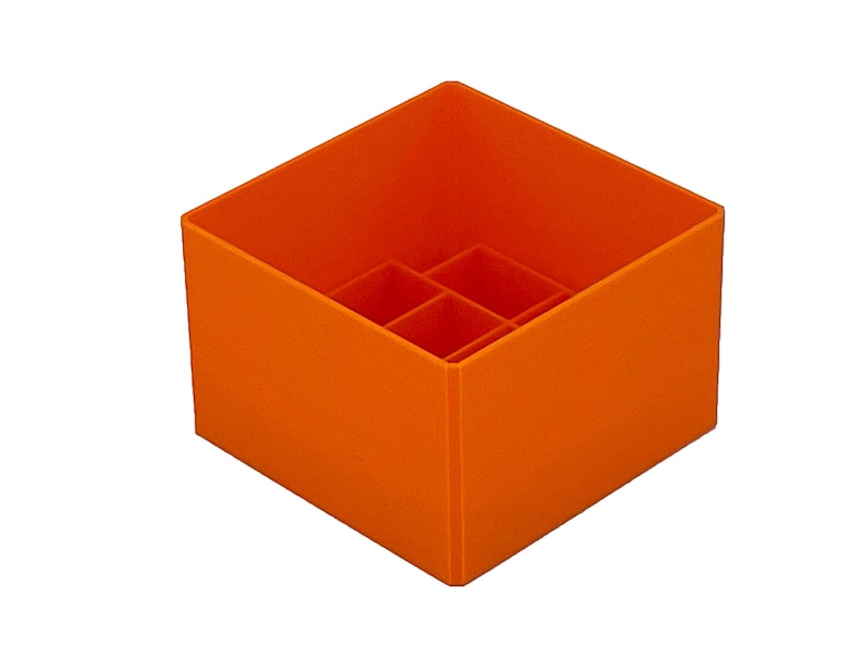 May include: Orange plastic organizer with six compartments. The organizer is square shaped and has a smooth surface.