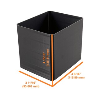 May include: A black, rectangular container with dimensions of 4 15/16 inches (125.41 mm) high, 4 9/16 inches (115.89 mm) wide, and 3 11/16 inches (93.662 mm) deep. The container is empty and has a matte finish.