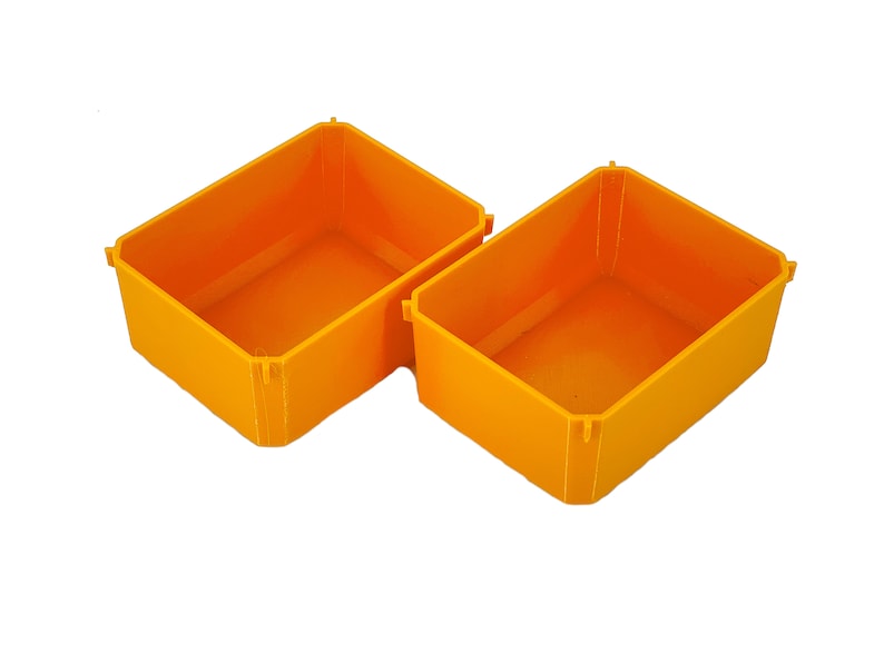 Puede incluir: Dos contenedores de almacenamiento de pl&aacute;stico de color naranja brillante con la parte superior abierta. Los contenedores son rectangulares y tienen un acabado liso y brillante.