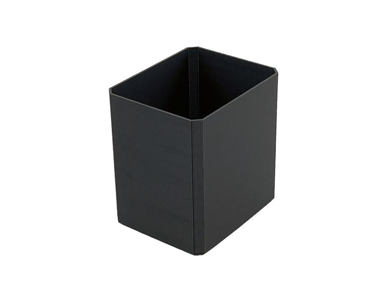 May include: A black, square-shaped container with an open top. The container is made of a solid, matte material and has a simple, modern design. The interior is also black. The container is suitable for office or home organization.