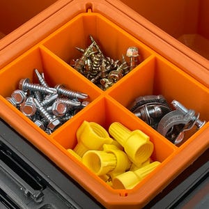 May include: An orange and black toolbox with an orange interior divided into four compartments. The compartments contain various hardware items, including screws, wire connectors, and other fasteners.