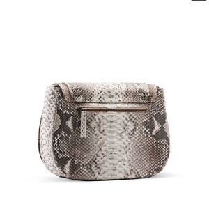 Pode incluir: Uma bolsa de m&atilde;o de couro de cobra com padr&atilde;o branco e marrom com fecho de correr.