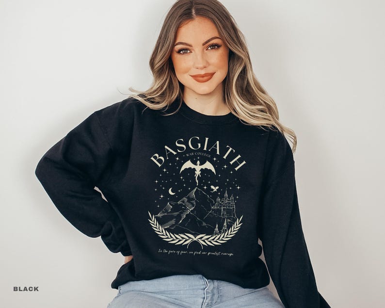 May include: Black sweatshirt with a graphic design featuring the word "BASGIATH" above a mountain scene with a castle, a winged figure, and the text "In the face of fear, we find our greatest courage."