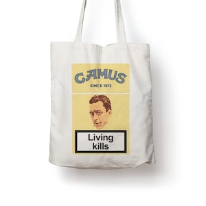 Può includere: Una borsa tote in tela bianca con una grafica gialla e rossa di un pacchetto di sigarette. Il pacchetto dice "CAMUS SINCE 1913" e "Living kills".