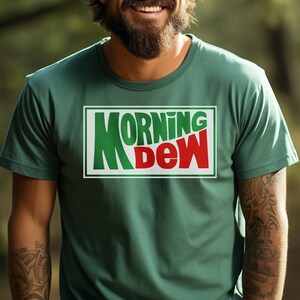 May include: A green t-shirt with a white rectangle featuring the text "MORNING DEW" in green and red letters.