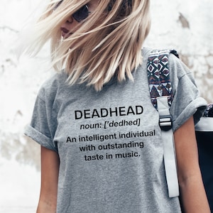 May include: Gray t-shirt with the text "DEADHEAD" and the definition: "noun: ['dedhed] An intelligent individual with outstanding taste in music."