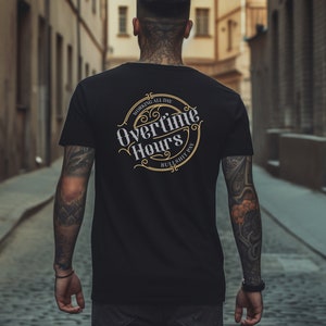 Op de afbeelding: Een zwart T-shirt met een gouden en wit grafisch ontwerp met de tekst "Overtime Hours Working All Day Bullshit Pay".