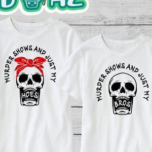 May include: Two white t-shirts with a black skull graphic and text that reads "Murder Shows and Just My" with the words "Hoes" and "Bros" below the skull.