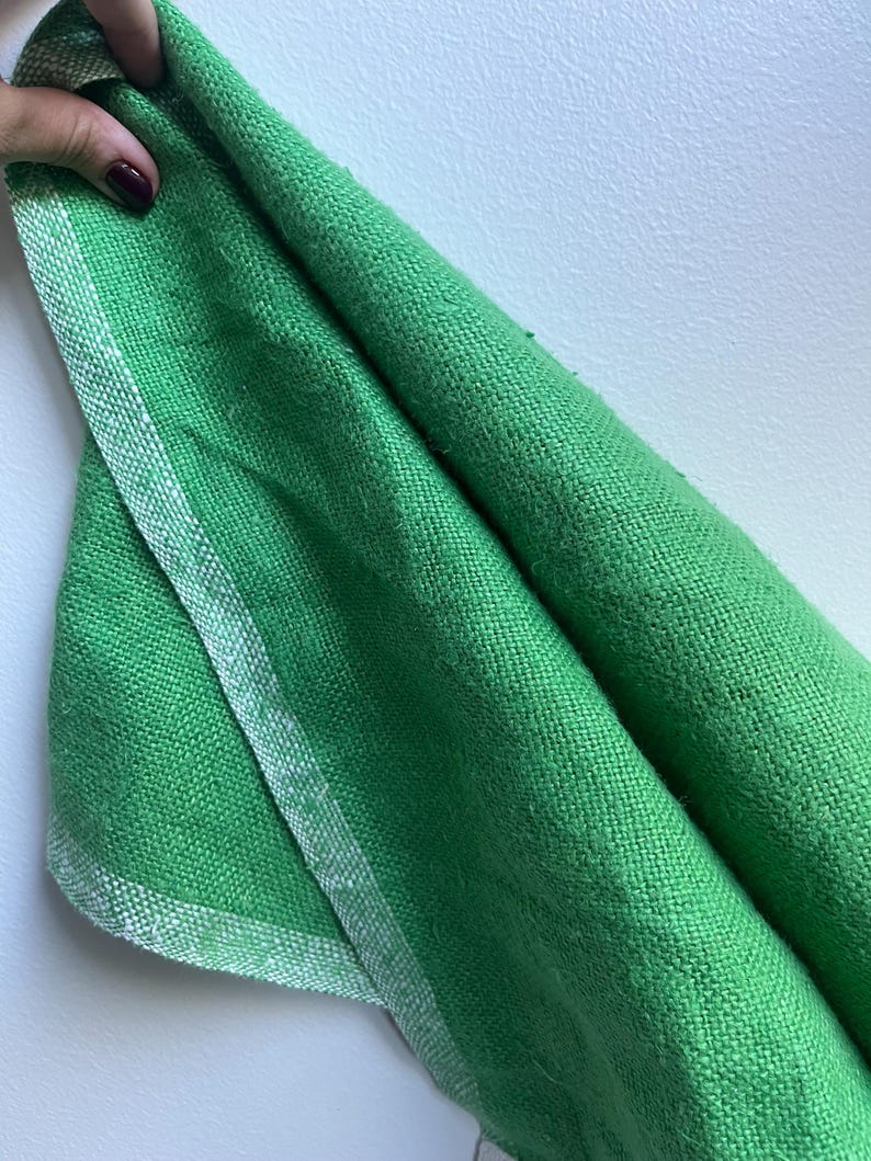 Pu&ograve; includere: Un tessuto verde con un bordo bianco. Il tessuto &egrave; piegato a met&agrave; e il bordo &egrave; visibile sul bordo.