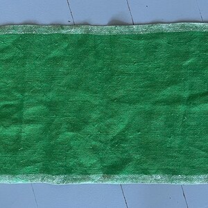 Pu&ograve; includere: Un runner da tavolo in lino verde con bordi bianchi. Il runner &egrave; largo circa 46 cm e lungo 122 cm.
