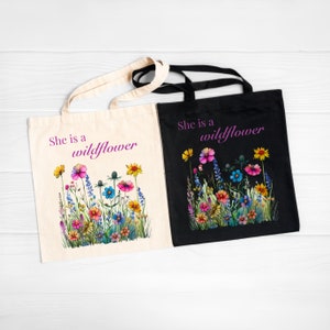 She is a wildflower, The Daisy Exchange, Gifts for her, bestie gifts, birthday gifts, best selling items, bridesmaid tote, embroidered tote, floral backpack, weekend bag, christian tote, farmers market bag, floral botanical canvas bag, everyday tote