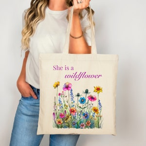 She is a wildflower, The Daisy Exchange, Gifts for her, bestie gifts, birthday gifts, best selling items, bridesmaid tote, embroidered tote, floral backpack, weekend bag, christian tote, farmers market bag, floral botanical canvas bag, everyday tote