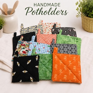 May include: A collection of square fabric potholders featuring various patterns including bees, palm trees, cherries, flowers, and geometric designs. The text HANDMADE Potholders is visible at the top. Each quilted potholder includes a small fabric loop.