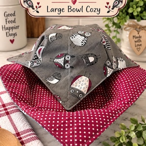 May include: A large bowl cozy featuring a gray exterior fabric with a repeating pattern of owls in black, white, and maroon. The interior fabric is a deep maroon with a white polka dot pattern. The text Hooty Dots Large Bowl Cozy is visible.