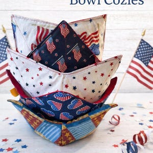 May include: Handmade bowl cozies in a stack, featuring patriotic patterns of flags and stars in red, white, and blue. The text "Handmade Bowl Cozies" is displayed in red and blue. Decorative confetti and small American flags are in the background.