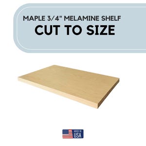 May include: A rectangular maple 3/4" melamine shelf, cut to size. The shelf is light brown and has a smooth surface. Text at the top reads "MAPLE 3/4" MELAMINE SHELF CUT TO SIZE". The bottom right corner has a "Made in USA" sticker.
