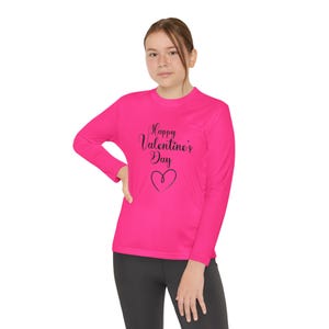 May include: A pink long-sleeved shirt with the text "Happy Valentine's Day" and a heart design in black.