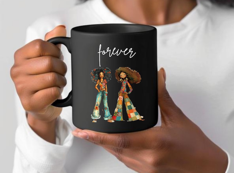 May include: Black ceramic mug featuring a colorful illustration of two women in retro outfits. The mug has the word "forever" in white script. The women are wearing bell-bottom jeans and patchwork pants.
