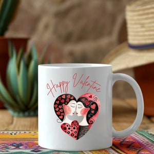 May include: White ceramic mug with a Valentine's Day theme. The mug features a heart-shaped design with two figures kissing, surrounded by red hearts. The words "Happy Valentine" are written in red script.
