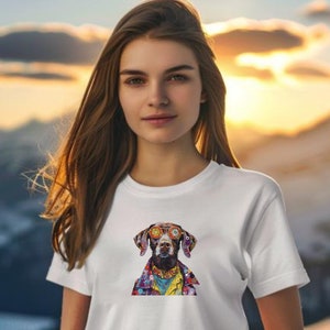 May include: A white t-shirt with a colorful graphic of a dog wearing sunglasses. The dog is wearing a colorful patterned shirt and has a yellow background.