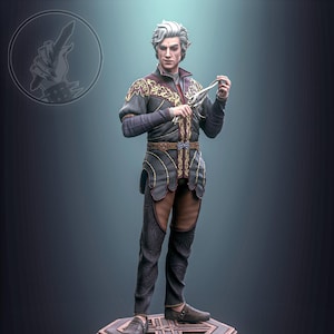 May include: A detailed figurine of a character in a dark outfit with gold accents, holding a small object. The figure stands on a multi-tiered, geometric base. The character has white hair and is wearing a dark outfit with gold embroidery.