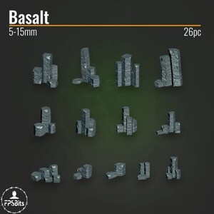 Könnte beinhalten: Ein Set mit 26 Basalt-Steinchen in den Größen von 5 bis 15 Millimetern. Die Steine sind grau und haben eine raue, strukturierte Oberfläche. Sie sind in verschiedenen Formationen angeordnet, darunter Stapel, Haufen und einzelne Steine.