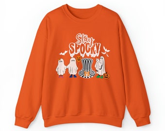 Könnte beinhalten: Orangefarbener Pullover mit dem Text "Stay Spooky" in Weiß. Das Design zeigt vier Geister, einer mit Zylinder und Fliege, und einen Kürbis.