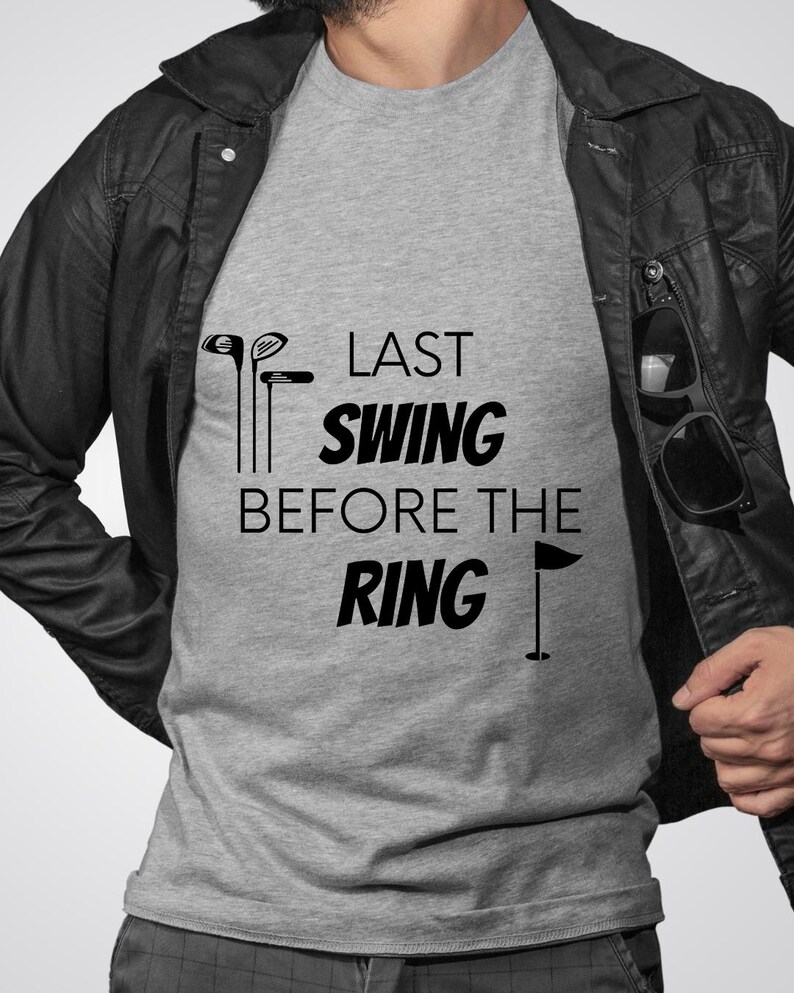May include: A gray t-shirt with the text "Last Swing Before The Ring" and a golf club and flag graphic.