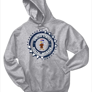 May include: A gray hooded sweatshirt with a blue and white distressed circle graphic featuring an eagle wearing a hat and holding a letter. The graphic says "United States Postal Worker".