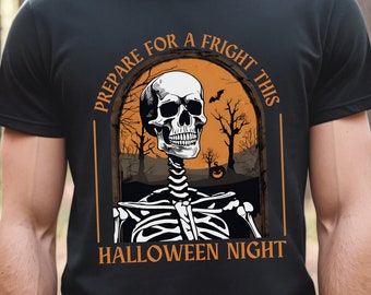 Könnte beinhalten: Schwarzes T-Shirt mit einem Halloween-Motiv. Das Design zeigt ein Skelett mit dem Text "PREPARE FOR A FRIGHT THIS HALLOWEEN NIGHT" in Orange. Der Hintergrund zeigt eine gruselige Szene mit Bäumen und einem Kürbis.