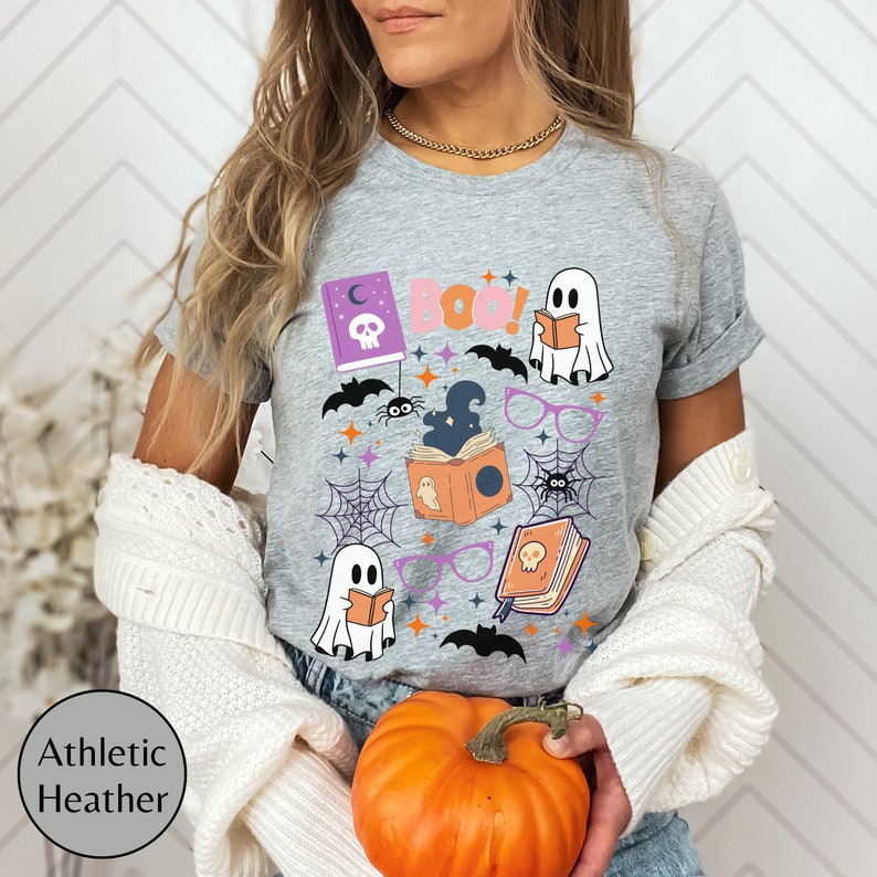 May include: Gray t-shirt with a Halloween-themed design featuring ghosts, bats, spiders, books, and the text "Boo!"