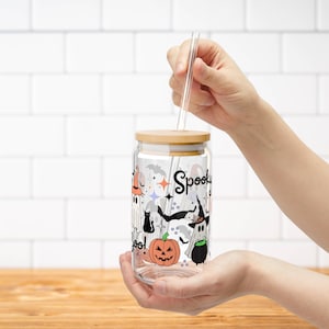 May include: A clear glass jar with a wooden lid and a straw. The jar has a Halloween-themed design with ghosts, bats, pumpkins, and the words "Spooky Boo!" printed on it.