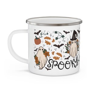 May include: White enamel mug with a spooky Halloween design featuring ghosts, bats, pumpkins, and leaves. The text "Spooky!" is written in black cursive.