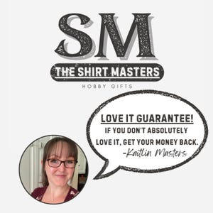 May include: The Shirt Masters logo with the initials "SM" in a distressed font. Below the logo is the text "THE SHIRT MASTERS" and "HOBBY GIFTS". A speech bubble states "LOVE IT GUARANTEE!" and a photo of Kaitlin Masters.
