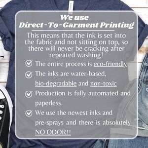 May include: A navy blue t-shirt with a white graphic that explains the Direct-To-Garment printing process. The text highlights eco-friendly, water-based, non-toxic inks, and automated production. The shirt is displayed with denim jeans and a black and white shoe.