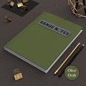 May include: Olive drab green notebook with a white spine and a gray patch that says "RANGE NOTES" with a target symbol.