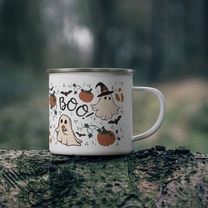 May include: White enamel camping mug with a Halloween design. The mug features ghosts, bats, pumpkins, and the word "Boo!" in black lettering.