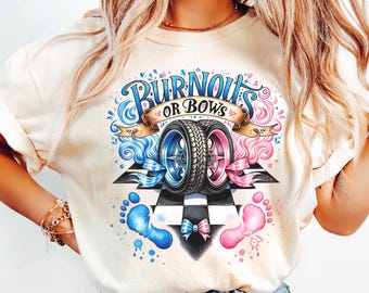 May include: Cream-colored t-shirt with a gender reveal design. The graphic features two car tires, one blue and one pink, with the text "Burnouts or Bows." Blue and pink ribbons, footprints, and a checkered flag complete the design.