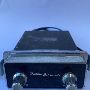 May include: A black and silver vintage car stereo with the text "Boman Astrosonix" and two knobs labeled "VOL" and "TU".