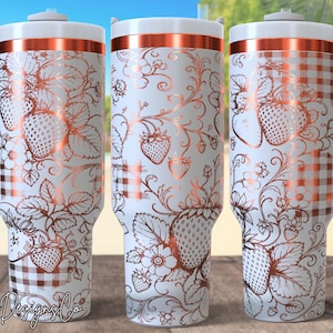 May include: A white stainless steel tumbler with a handle and a copper-colored lid rim. The exterior features a metallic copper-toned line art pattern of strawberries, leaves, and vines, interspersed with sections of a copper-colored gingham check.