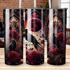 May include: A set of three stainless steel tumblers with a gothic design. Each tumbler features a black raven perched on a branch, surrounded by red roses, skulls, and a stained-glass window design. The background has a red moon and starry sky.