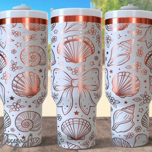 May include: White insulated tumbler with a rose gold seashell and floral pattern. The tumbler has a white handle and lid with a rose gold band. The design includes various seashell illustrations, stars, and flowers. The tumbler is designed for cold beverages.