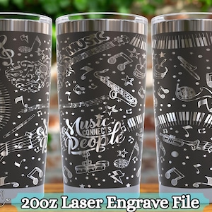 Op de afbeelding: Drie zwarte 591ml-bekers met zilveren lasergegraveerde muziekinstrumentontwerpen. De tekst "Music connects People" staat op één beker. Andere ontwerpen zijn pianotoetsen, muzieknoten en instrumenten.