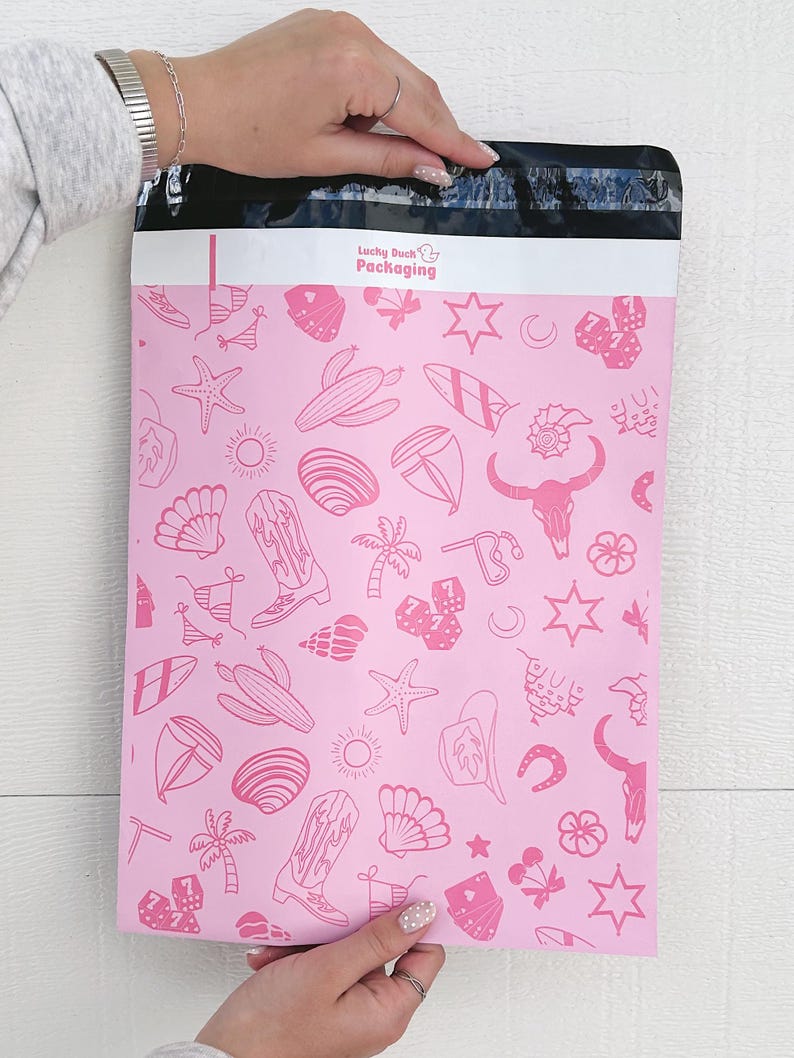 May include: Pink poly mailer with a white border and a repeating pattern of pink line drawings of various objects, including stars, palm trees, surfboards, seashells, cowboy boots, dice, and a bull skull. The text "Lucky Duck Packaging" is printed in white at the top of the mailer.
