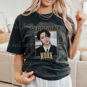 May include: Black t-shirt with a gold graphic of a man with the text "SEONGHWA ATEEZ WORK" on it.