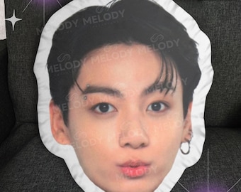 May include: White pillow with a printed image of a person's face. The person has dark hair and is looking at the camera with a slight smile. The pillow has a ruffled edge.