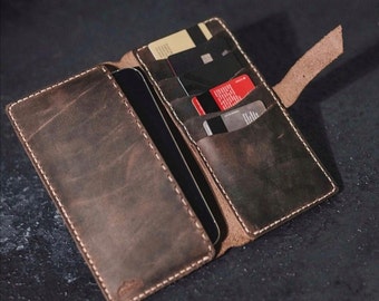 Może przedstawiać: Brązowy skórzany portfel ze szwem i klapką. Portfel ma wiele przegródek na karty i kieszeń na telefon.